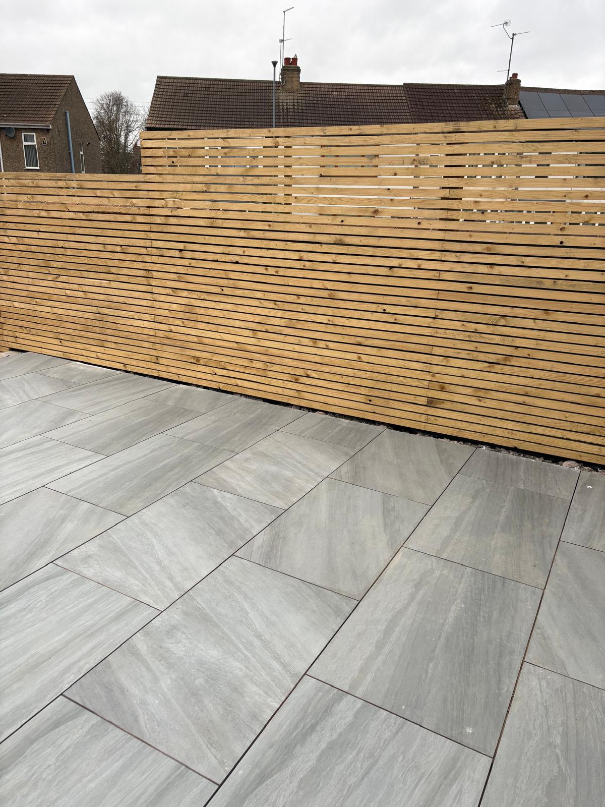Grey paving beside a newly fitted horizontal timber fence