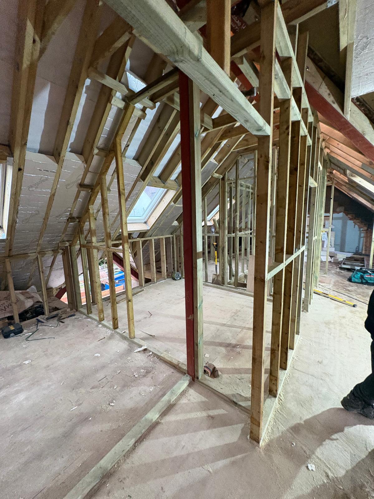 Timber partition framing and roof structure inside a loft under construction
