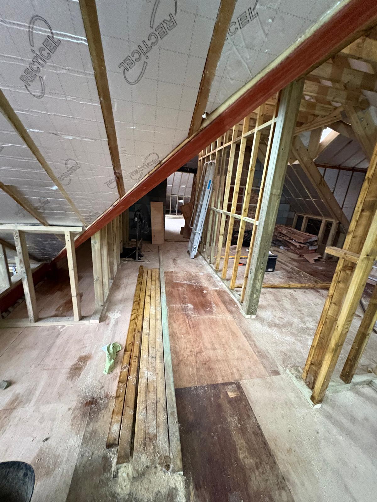 Timber framing and insulation inside an unfinished loft